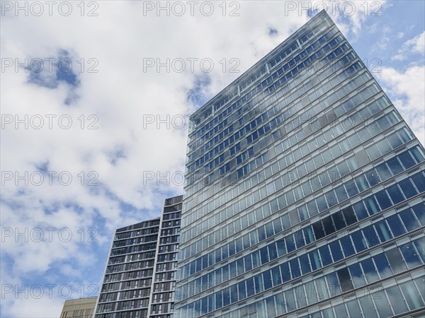 Modern skyscrapers with glass facades in Luxembourg under a slightly cloudy sky, modern buildings with trees and glass facades, luxembourg