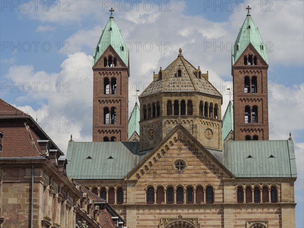 Detailed shot of a historic church with green towers and blue sky in the background, large cathedral with two towers in front of blue sky with clouds, Speyer, Germany, Europe