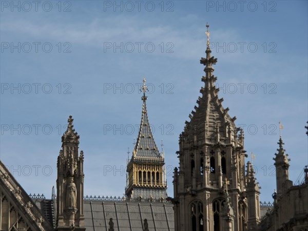 Detail of a gothic building with towers and roof spires, smaller tower in the background, blue sky, London, England, Great Britain