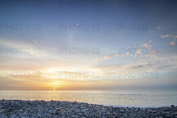 Sunrise with sea view in a lonely bay. rocky coast in warm colours. Landscape with a lava stone beach of Tarajalejo on Fuerteventura, Canary Islands, Spain, Europe
