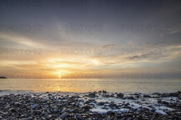 Sunrise with sea view in a lonely bay. rocky coast in warm colours. Landscape with a lava stone beach of Tarajalejo on Fuerteventura, Canary Islands, Spain, Europe