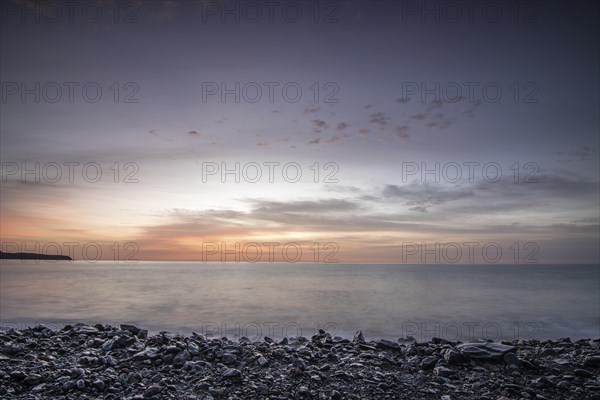 Sunrise with sea view in a lonely bay. rocky coast in warm colours. Landscape with a lava stone beach of Tarajalejo on Fuerteventura, Canary Islands, Spain, Europe