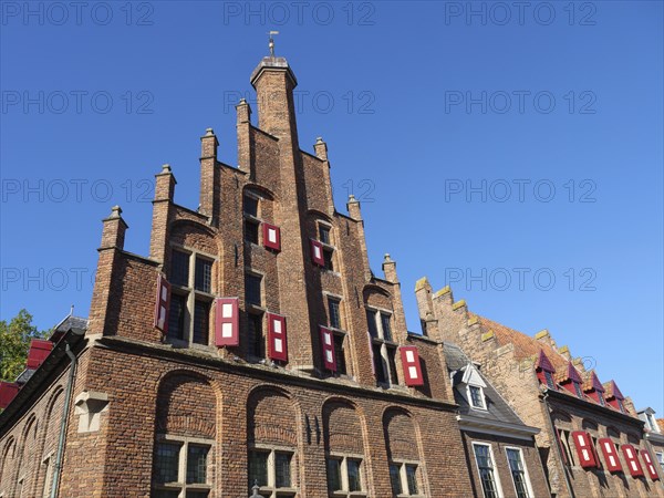 Gothic building with red shutters under a clear blue sky, red brick houses and churches in the Netherlands, Doesburg, Netherlands