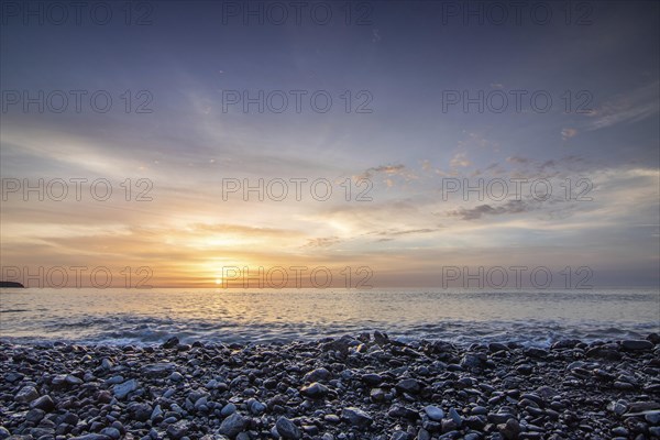 Sunrise with sea view in a lonely bay. rocky coast in warm colours. Landscape with a lava stone beach of Tarajalejo on Fuerteventura, Canary Islands, Spain, Europe