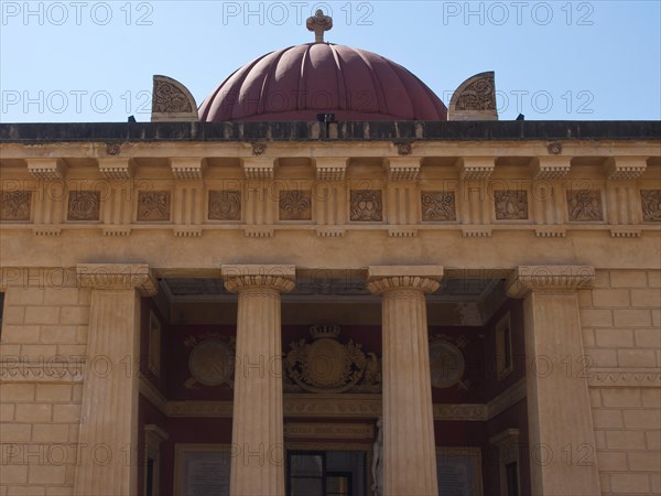 An impressive facade with columns and a dome in the background, palermo in sicily with an impressive cathedral, monuments and old houses with balconies, palm trees and flowers in italy, palermo, sicily