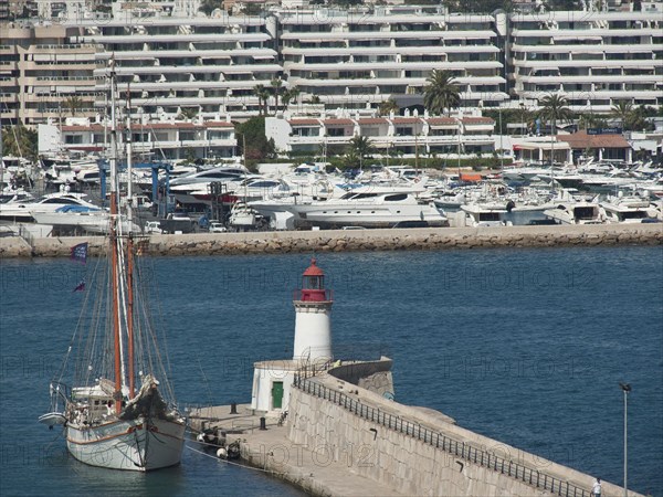 Harbour with a large sailing ship and a lighthouse, surrounded by blue buildings and yachts, ibiza, Spain, Europe