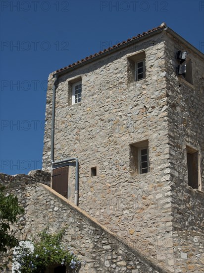 A three-storey stone house with small windows under a clear blue sky, Provence, le Castellet, France, Europe