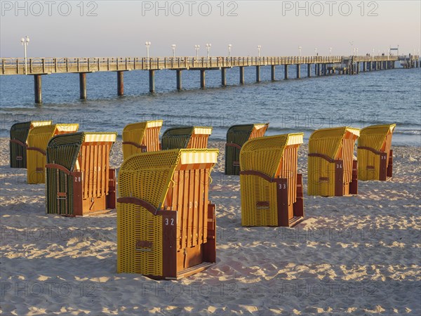 Beach chairs near a pier on the beach at sunset, quiet and peaceful atmosphere, autumn atmosphere on the beach of Binz with trees beach chairs in the morning light, Binz, germany