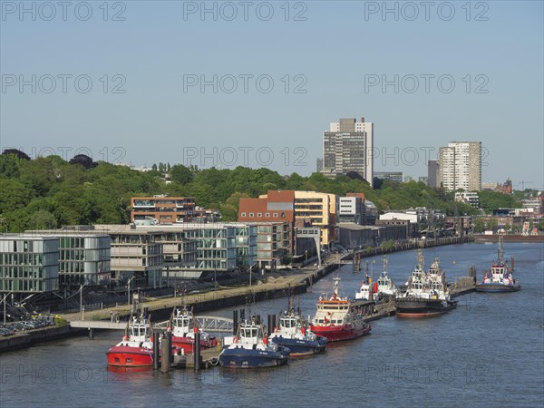 River section with modern buildings and numerous boats under a clear sky in the summer, beautiful city on the river with harbour, shipyards, houses and ships, Hamburg, Germany, Europe