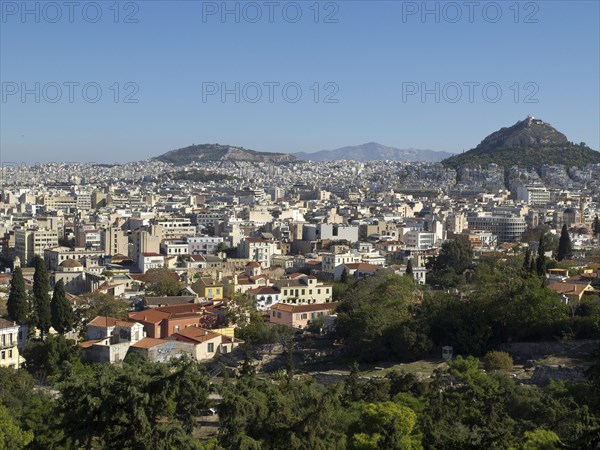 City silhouette with various houses in front of a hilly background, Ancient buildings with columns and trees on the Acropolis in Athens in front of a blue sky, athens, greece