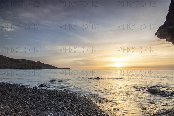 Sunrise with sea view in a lonely bay. rocky coast in warm colours. Landscape with a lava stone beach of Tarajalejo on Fuerteventura, Canary Islands, Spain, Europe