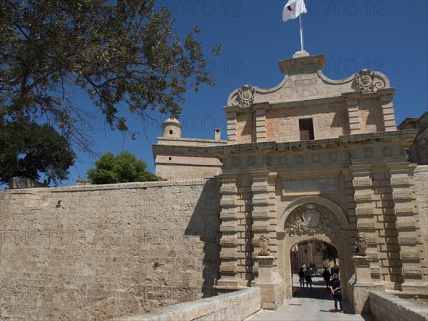 Large sandstone city gate with visitor access and historic charm under a blue sky, the town of mdina on the island of malta with historic houses, colourful balconies, magnificent churches, mdina, Malta, Europe