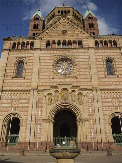 Frontal view of a gothic sandstone cathedral facade with towers under a blue sky, large cathedral with two towers in front of a blue sky with clouds, Speyer, Germany, Europe