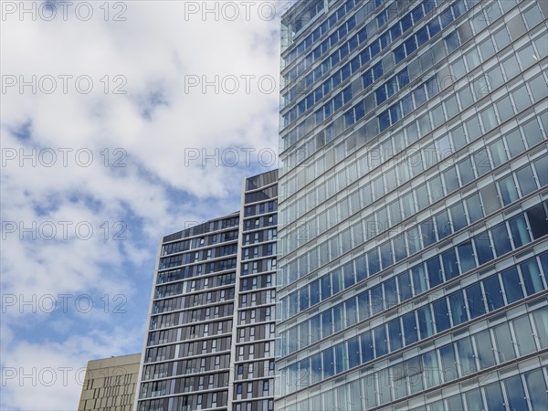 Close-up of modern skyscrapers in Luxembourg with glass facades under a slightly cloudy sky, modern buildings with trees and glass facades, luxembourg
