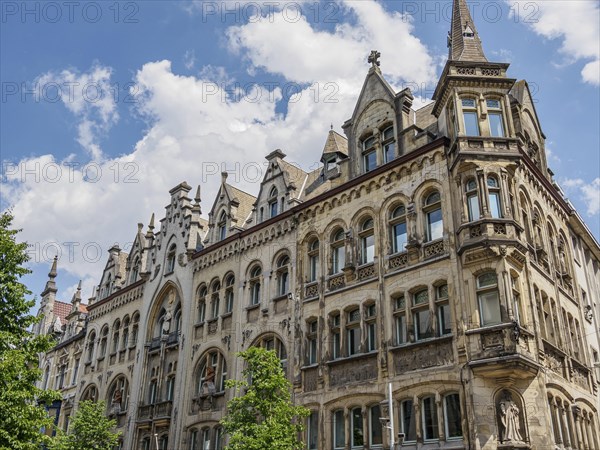 Two-storey building in neo-Gothic style with gabled towers and ornate windows under a cloudy sky, skyline of a historic city on the river with old facades and beautiful towers, Ghent, Belgium, Europe