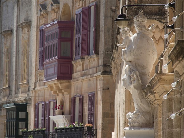 A building facade with colourful shutters, balconies and a statue, the town of mdina on the island of malta with historic houses, colourful balconies, magnificent churches, mdina, Malta, Europe
