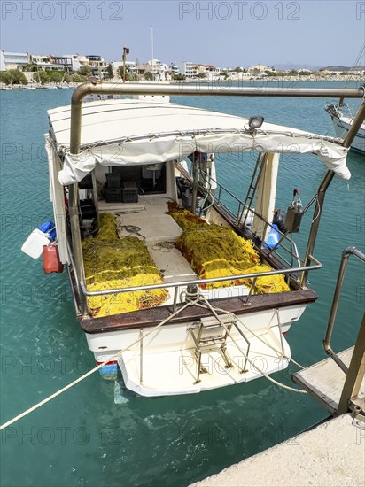 Fishing boat moored to quay wall in Kokkinos Pyrgos harbour, yellow fishing nets on board, Kokkinos Pyrgos, Crete, Greece, Europe