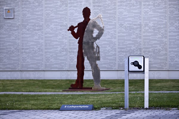 E-charging car park in front of miner's sculpture, Pluto colliery, structural change, Wanne-Eickel, Herne, Ruhr area, North Rhine-Westphalia, Germany, Europe
