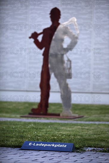 E-charging car park in front of miner's sculpture, Pluto colliery, structural change, Wanne-Eickel, Herne, Ruhr area, North Rhine-Westphalia, Germany, Europe