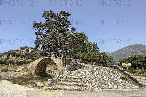 View of stairway with coarse cobblestones of historic classical arched stone bridge in Venetian architectural style Venetian Great Old Bridge 19th century stone bridge built in 1850 in Ottoman times over the middle reaches of river Megalopotamos at Preveli, Agios Vasilios, Crete, Greece, Europe