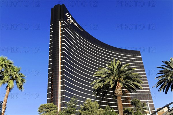 Las Vegas, Nevada, USA, North America, The domed skyscraper of the Wynn Hotel in Las Vegas, surrounded by palm trees, in front of a clear blue sky, Las Vegas Strip, North America