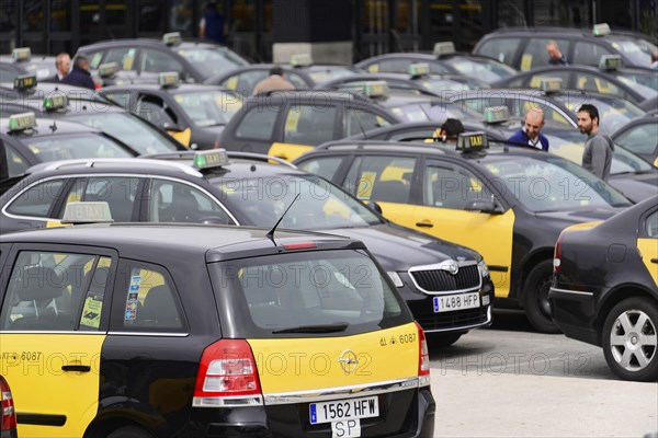 Barcelona, Catalonia, Spain, Europe, Many yellow-black taxis parked in a car park, people moving around, Europe
