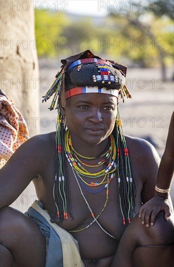 Hakaona woman with traditional kapapo hairstyle and colourful necklaces, in the morning light, Angolan tribe of the Hakaona, near Opuwo, Kunene, Namibia, Africa