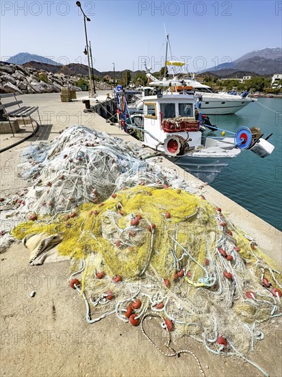 In front fishing nets nets of fishermen behind moored fishing boat moored to quay wall in harbour of Kokkinos Pyrgos, Kokkinos Pyrgos, Crete, Greece, Europe