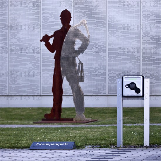 E-charging car park in front of miner's sculpture, Pluto colliery, structural change, Wanne-Eickel, Herne, Ruhr area, North Rhine-Westphalia, Germany, Europe