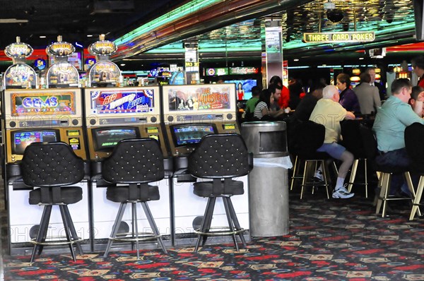 Las Vegas, Nevada, USA, North America, Interior view of a casino in Las Vegas with gambling machines, chairs and people playing at tables, Las Vegas Strip, North America