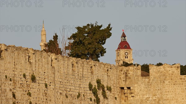 Clock tower, Minaret, A historic city wall with towers and a clock in the evening light, Old Town of Rhodes, Rhodes Town, Rhodes, Dodecanese, Greek Islands, Greece, Europe