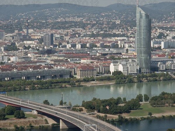 Panorama of an urban landscape with a dominating skyscraper next to a river, Vienna, Austria, Europe