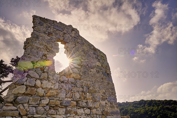 Stone wall of the ruin with a hole through which the sun shines, surrounded by cloudy sky, Kastro Monolithou, Monolithos Castle, rock castle, Monolithos village, Rhodes, Dodecanese, Greek Islands, Greece, Europe