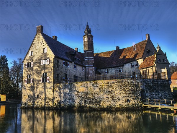 Medieval castle with moat and large tower, which stands out due to a reflection in the water, lüdinghausen, westphalia, germany