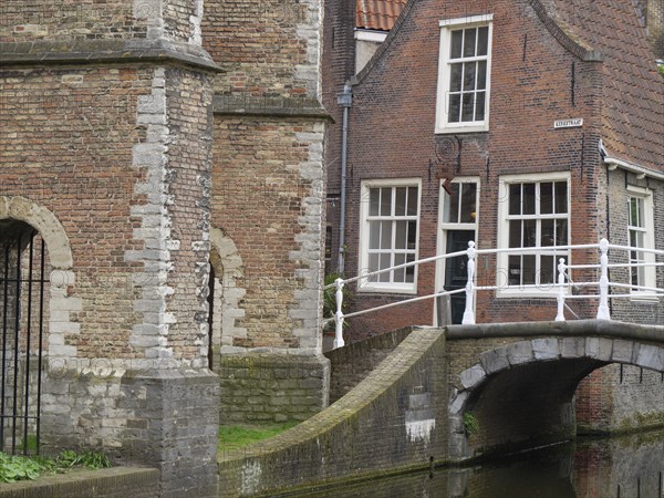Traditional view of an old brick building with a small bridge over a canal, Delft, Holland, Netherlands