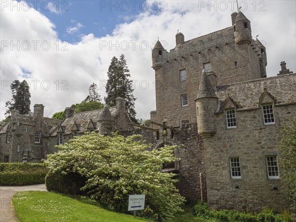 Castle with high towers and stone walls under a cloudy sky, surrounded by green lawns, inverness, scotland, Great Britain