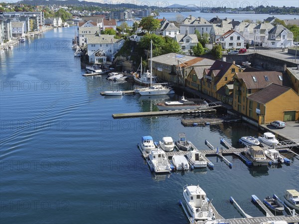 Harbour with many boats and wooden houses along the water in sunny weather, haugesund, norway, scandinavia