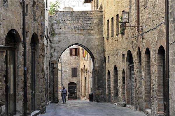 Old Town San Gimignano, Tuscany, Italy, Europe, A quiet, narrow alleyway in an old town with stone arches and historic buildings, Europe