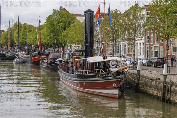 A steamboat in the harbour, surrounded by other boats and historic buildings, several flags can be seen, Dordrecht, holland, netherlands