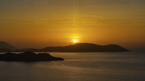A sunset over the sea, bathing the sky in golden colours and showing tranquil islands in the background, Makri Island, Alimia Island, Chalki Island, Kritinia Castle, St John's Castle, Kritinia, Rhodes, Dodecanese, Greek Islands, Greece, Europe