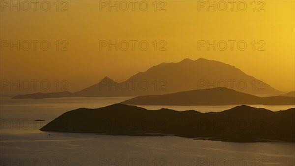 Golden sunset over the sea with silhouetted mountains in the background, Makri Island, Alimia Island, Chalki Island, Kritinia Castle, St John's Castle, Kritinia, Rhodes, Dodecanese, Greek Islands, Greece, Europe