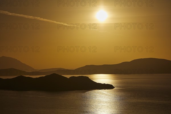 Golden sunset over calm sea with silhouetted archipelago, Makri Island, Alimia Island, Chalki Island, Kritinia Castle, St John's Castle, Kritinia, Rhodes, Dodecanese, Greek Islands, Greece, Europe