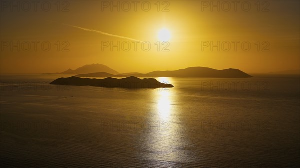 Sunset over calm sea with islands in golden light, Makri Island, Alimia Island, Chalki Island, Kritinia Castle, St John's Castle, Kritinia, Rhodes, Dodecanese, Greek Islands, Greece, Europe