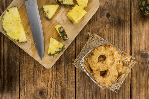 Pineapple rings (dried) on rustic wooden background as close-up shot