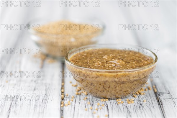Mustard (sweet) on rustic wooden background (close-up shot)