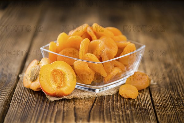 Dried Food (Apricots) on an old wooden table as detailed close-up shot (selective focus)