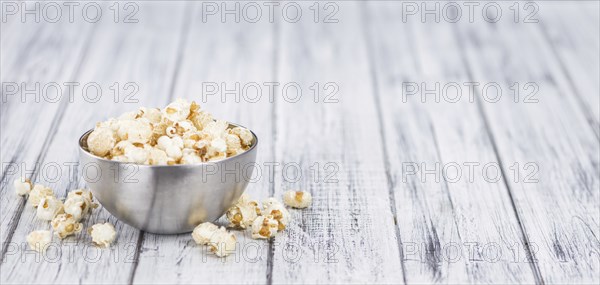 Fresh made Popcorn on an old and rustic wooden table, selective focus, close-up shot