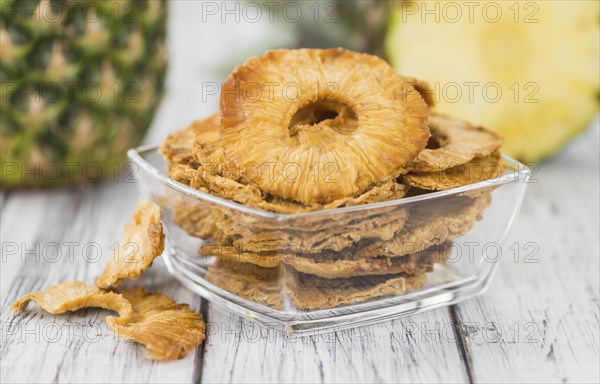 Pineapple rings (dried) on rustic wooden background as close-up shot