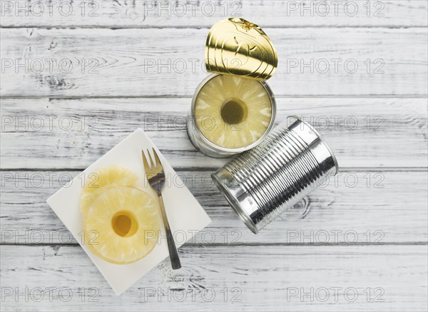 Preserved Pineapple Rings as high detailed close-up shot on a vintage wooden table, selective focus
