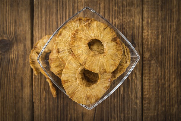 Pineapple rings (dried) on rustic wooden background as close-up shot